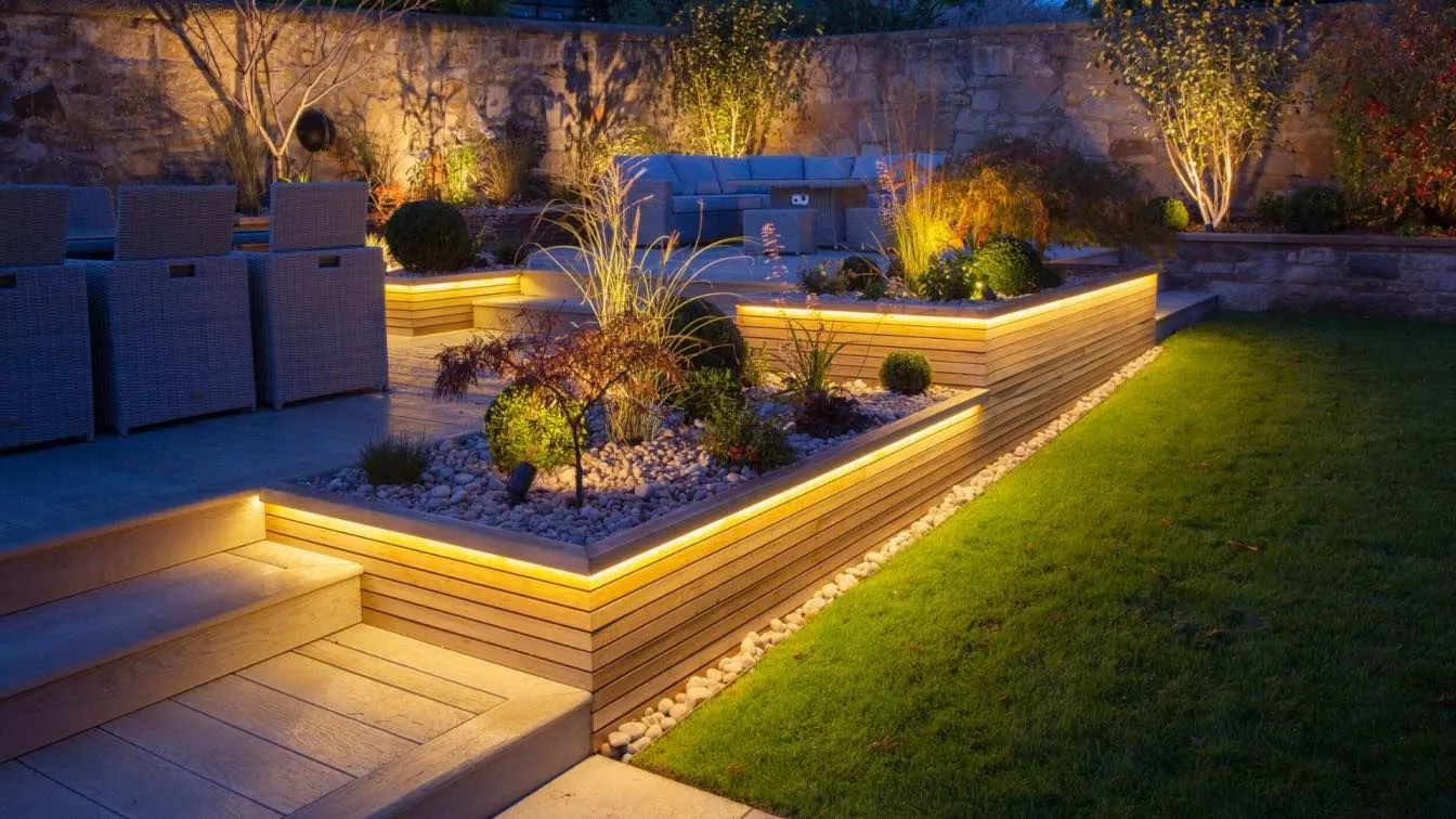 Backyard landscape lighting illuminating a garden retaining wall at night